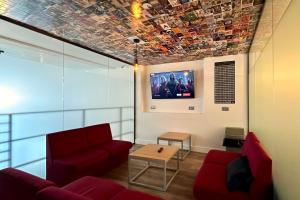 uma sala de estar com um sofá e uma televisão no tecto em Smart Camden Inn Hostel em Londres