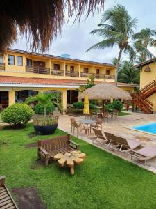 um resort com um quintal com bancos e uma piscina em Pousada Vivenda Oriente em São José da Coroa Grande