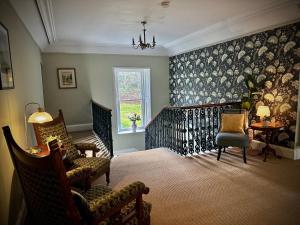 a living room with a chair and a staircase at Spean Lodge in Spean Bridge