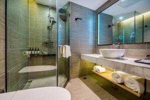 a bathroom with a sink and a glass shower at Sky Hotel - Shenzhen Luohu Sungang BaoNeng Center in Shenzhen