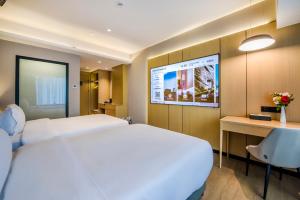 a hotel room with two beds and a projection screen at Sky Hotel - Shenzhen Luohu Sungang BaoNeng Center in Shenzhen