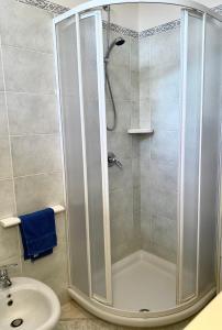 a shower with a glass door next to a sink at Casa vacanza comoda con vista in Bosa