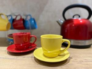 dos tazas y platillos en una mesa con tetera en Mariette's Cottage, en Arniston