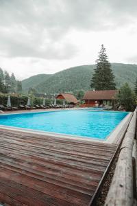 a large blue swimming pool with mountains in the background at Jazierce in Ružomberok