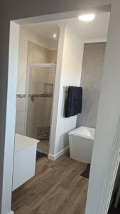 La salle de bains est pourvue d'une douche, d'un lavabo et de toilettes. dans l'établissement Dappled Dreams Unit 1, à Langebaan