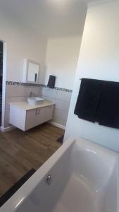 La salle de bains blanche est pourvue d'un lavabo et d'un miroir. dans l'établissement Dappled Dreams Unit 1, à Langebaan