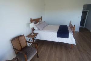 - une chambre avec un lit, une chaise et une lampe dans l'établissement Dappled Dreams Unit 1, à Langebaan