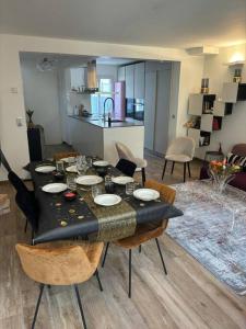 une salle à manger avec une table et des chaises ainsi qu'une cuisine dans l'établissement Maison 8 voyageurs à 15mn des champs élysées, à Asnières-sur-Seine