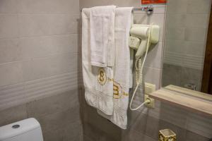 un bagno con telefono e asciugamani sul muro di Belona Hotel a Kutaisi