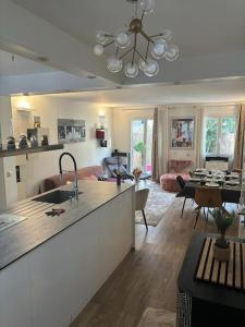 a kitchen and living room with a sink and a table at Maison 8 voyageurs à 15mn des champs élysées in Asnières-sur-Seine