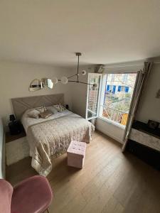 - une chambre avec un lit, une fenêtre et une chaise dans l'établissement Maison 8 voyageurs à 15mn des champs élysées, à Asnières-sur-Seine