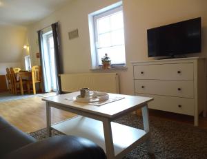 uma sala de estar com uma mesa de centro e uma televisão em Bauernhaus FeWo 3 em Grömitz