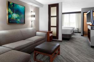 Habitación de hotel con sofá y cama en Hyatt Place Detroit/Auburn Hills, en Auburn Hills