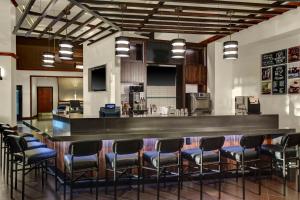 eine Bar in einem Zimmer mit einem Haufen Stühle in der Unterkunft Hyatt Place Detroit/Auburn Hills in Auburn Hills