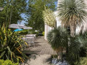 a patio with tables and chairs and an umbrella at ibis budget Bordeaux Aéroport in Mérignac