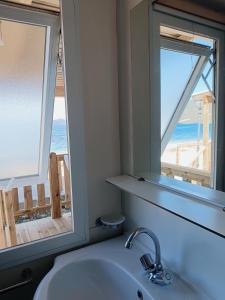 a bathroom with a sink and a view of the ocean at Camping Karavomilos in Sami