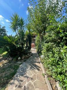 een stenen loopbrug met bomen en planten aan de zijkant bij Villino Circeo in San Felice Circeo