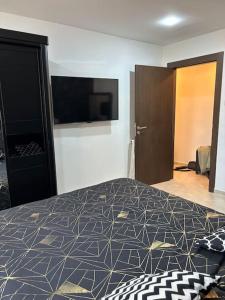 Schlafzimmer mit einem Bett und einem Flachbild-TV in der Unterkunft La perle de maraval in Oran