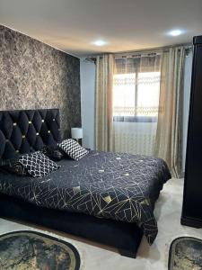 Schlafzimmer mit einem Bett und einem Fenster in der Unterkunft La perle de maraval in Oran