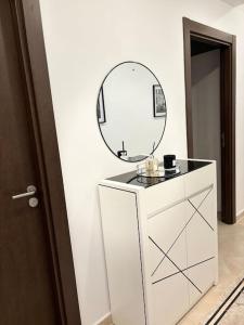 ein Badezimmer mit einem Spiegel auf der Kommode in der Unterkunft La perle de maraval in Oran