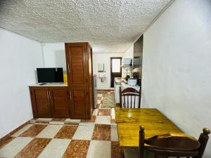 ein Wohnzimmer mit einem Tisch und einer Küche in der Unterkunft Verolux bedroom service in Quatre Bornes