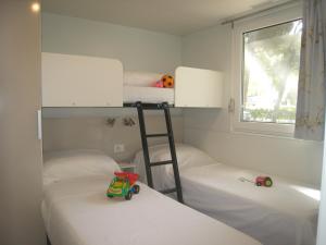 En eller flere senge i et værelse på Piomboni Camping Village