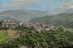 uma aldeia numa colina com montanhas ao fundo em Il Rifugio del Cuore em Collestatte