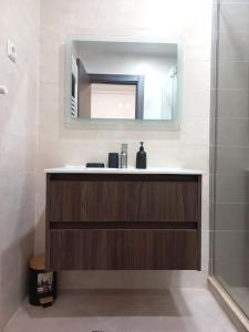 ein Bad mit einem Waschbecken und einem Spiegel in der Unterkunft La perle de maraval in Oran
