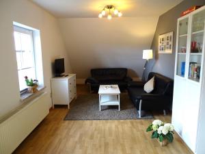 uma sala de estar com um sofá e uma mesa em Bauernhaus FeWo 3 em Grömitz