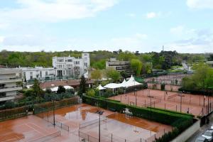 a view of a tennis court with two tennis courts at Charmant Appartement au Cœur de Boulogne in Boulogne-Billancourt