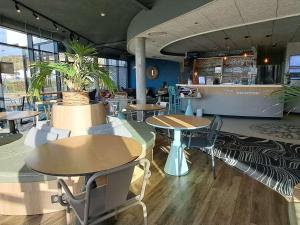 un restaurant avec des tables, des chaises et un comptoir dans l'établissement ibis Budget Le Treport Mers Les Bains, à Mers-les-Bains