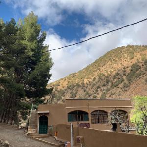 a house in front of a mountain at Guest House Tigminou in Setti Fatma