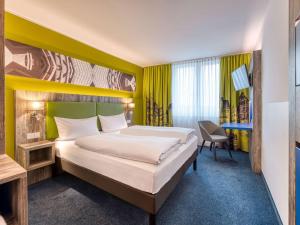 um quarto de hotel com uma cama e uma secretária em ibis Styles Tuebingen em Tübingen