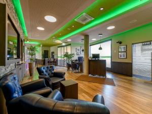 a lobby with leather furniture and green lights at ibis Styles Tuebingen in Tübingen