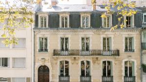 a large building with a balcony on the side of it at Les Suites de L’Opéra in Vichy