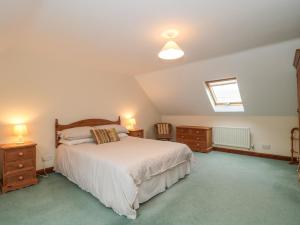 1 dormitorio con 1 cama, 2 vestidores y ventana en Cartshed Cottage, en Weymouth