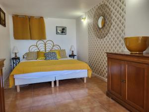 1 dormitorio con cama y tocador de madera en Les Trois Chênes, en Les Angles