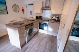 a kitchen with a washer and dryer in it at Jura Apartment in Oban