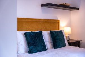 a bed with two green pillows on top of it at Jura Apartment in Oban