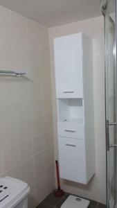 uma casa de banho branca com um WC e um armário em Dalia 13 em Pafos