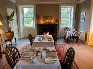 a dining room with two tables and a fireplace at Spean Lodge in Spean Bridge