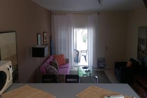 a living room with a pink couch and a window at Dalia 13 in Paphos City