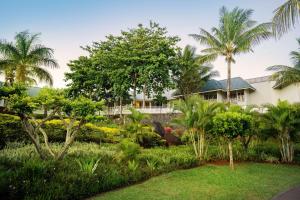 a garden in front of a house with palm trees at Radisson Blu Azuri Resort & Spa in Roches Noires