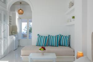 a white living room with a couch and a table at Nevma Suites in Firostefani