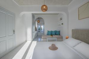 a white living room with a couch and a table at Nevma Suites in Firostefani