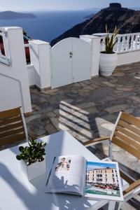 a table with an open book on it on a patio at Nevma Suites in Firostefani