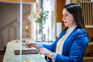 Een vrouw in een blauw pak zit aan een tafel. bij Apartamenty Pod Ratuszem in Rzeszów