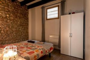 佩皮尼昂的住宿－Atlas - Nexus，一间卧室设有一张床和砖墙