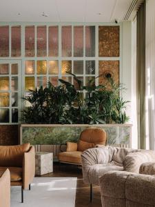 a living room with a couch and some plants at PURO Hotel Poznań Stare Miasto in Poznań