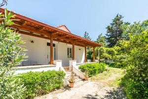 a white house with a wooden roof at Athenian 2BR Cottage with Garden & BBQ near Metro in Athens